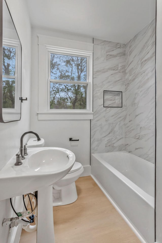full bath featuring plenty of natural light, toilet, and wood finished floors