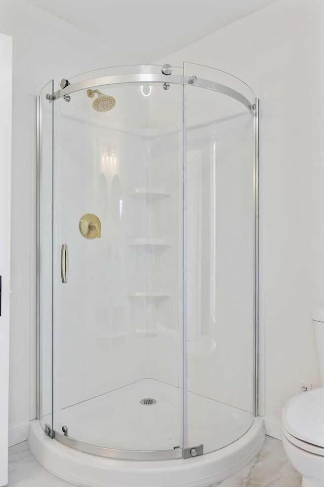 bathroom featuring a shower stall and toilet