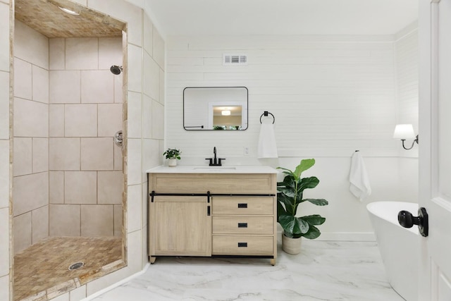 full bathroom featuring marble look tile flooring, a stall shower, a soaking tub, and vanity