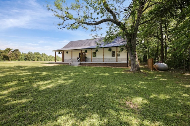 view of front facade with a porch, a front yard, and metal roof