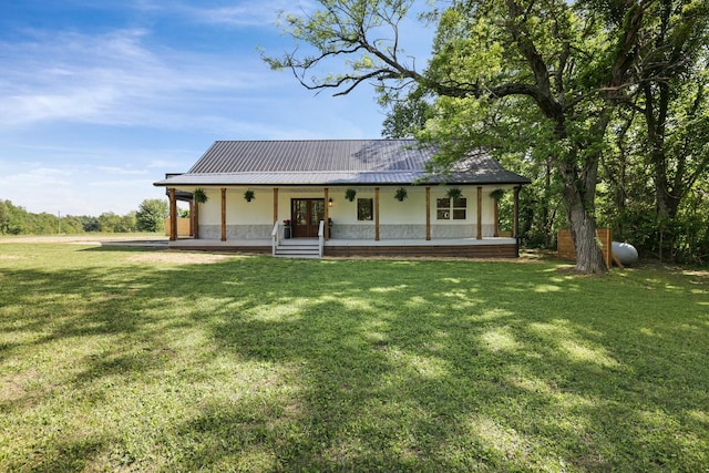view of front facade featuring covered porch, a front yard, metal roof, and french doors
