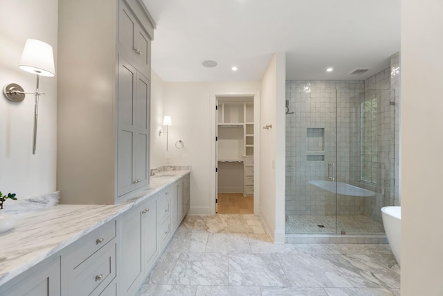 full bath with a stall shower, vanity, recessed lighting, a spacious closet, and baseboards