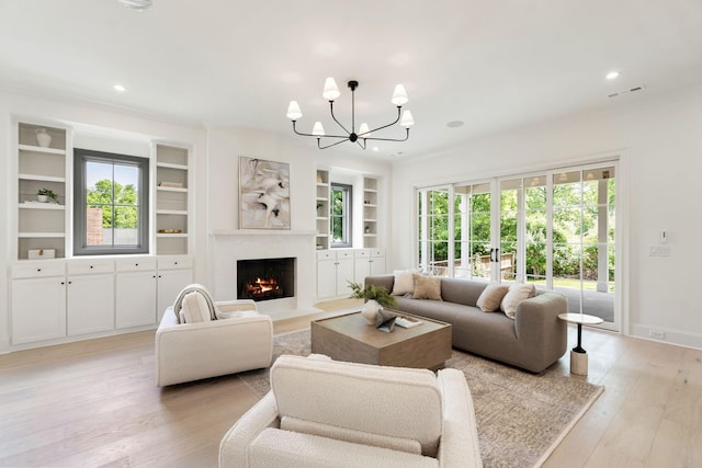 living room with a chandelier, light wood-style flooring, built in features, a premium fireplace, and recessed lighting