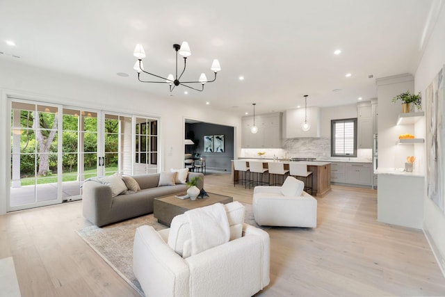 living area featuring light wood-style flooring, recessed lighting, and a chandelier