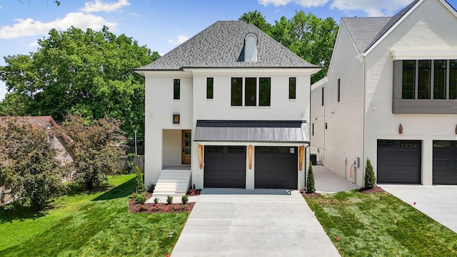 view of front of home with driveway, an attached garage, a front lawn, and a standing seam roof