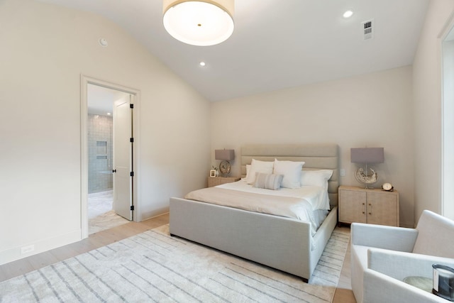 bedroom featuring light wood finished floors, lofted ceiling, recessed lighting, baseboards, and ensuite bath