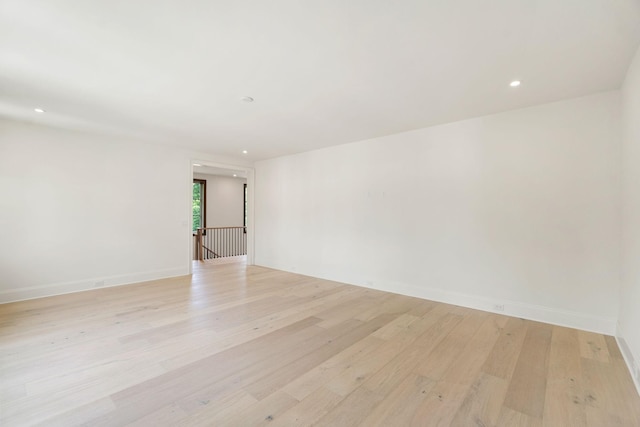 empty room featuring light wood-type flooring, recessed lighting, and baseboards