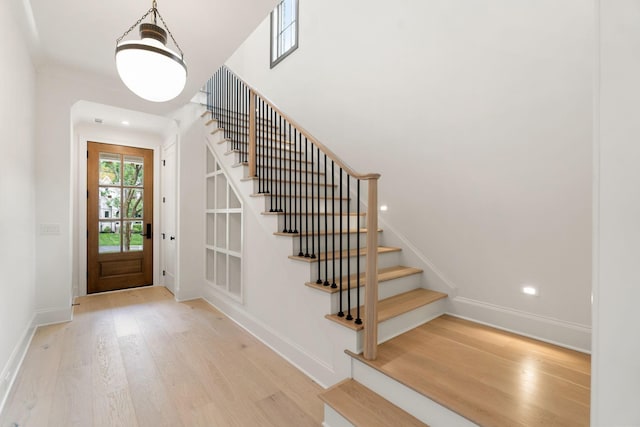 entrance foyer with wood finished floors, stairs, and baseboards