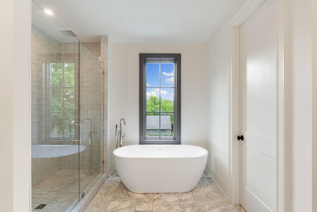 bathroom featuring a stall shower, a soaking tub, and marble look tile flooring