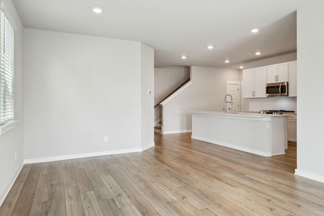 440 Golden Meadow Ln, Hendersonville, TN 37075 - kitchen with stainless steel microwave, light wood finished floors, recessed lighting, a kitchen island with sink, and decorative backsplash
