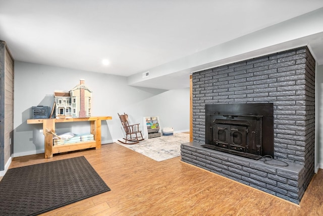 living area with wood finished floors, a fireplace, baseboards, and recessed lighting