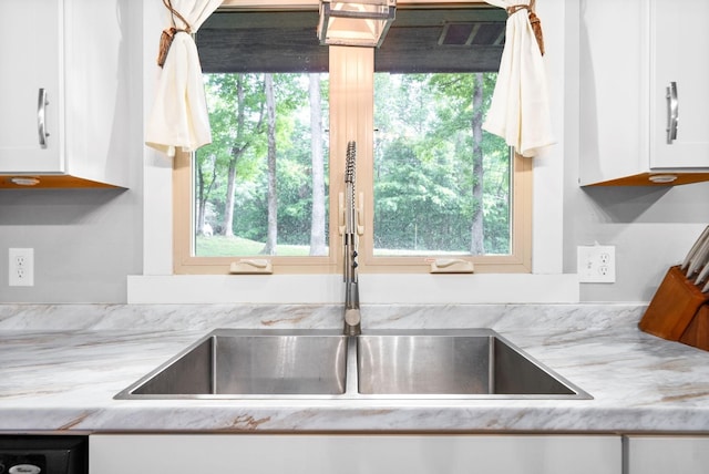 kitchen with a sink, white cabinets, and plenty of natural light