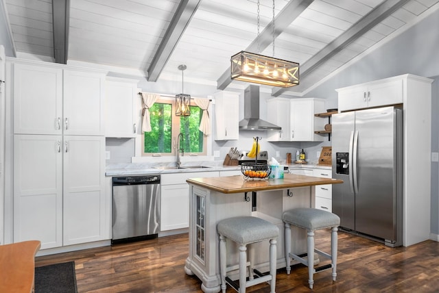 kitchen with appliances with stainless steel finishes, wall chimney range hood, a sink, white cabinetry, and dark wood finished floors