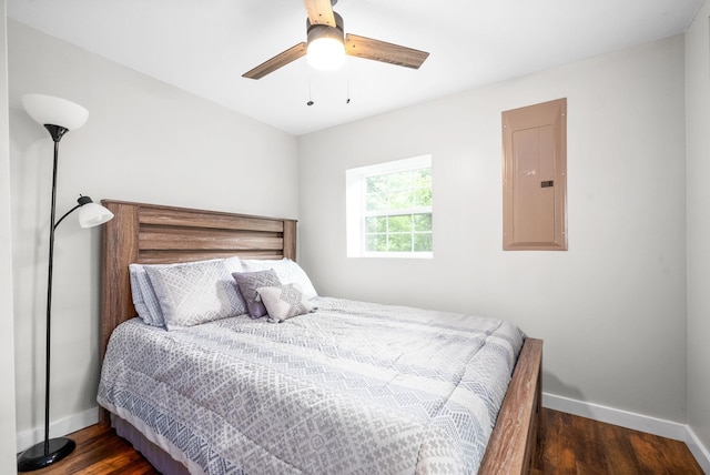 bedroom featuring electric panel, baseboards, wood finished floors, and ceiling fan
