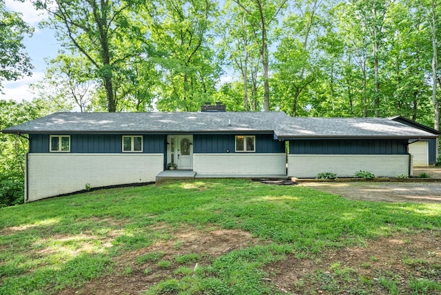 single story home with brick siding, a chimney, a front lawn, and a shingled roof
