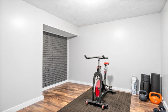 exercise room featuring wood finished floors and baseboards