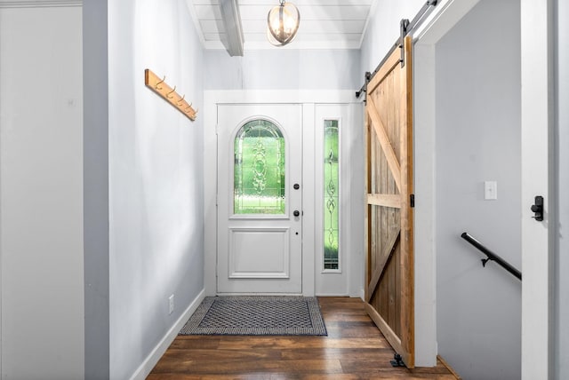 entrance foyer with a barn door, wood finished floors, baseboards, and beam ceiling
