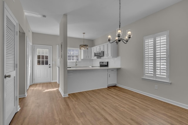 2732 Linmar Ave, Nashville, TN 37215 - kitchen with appliances with stainless steel finishes, a chandelier, light wood finished floors, light countertops, and baseboards