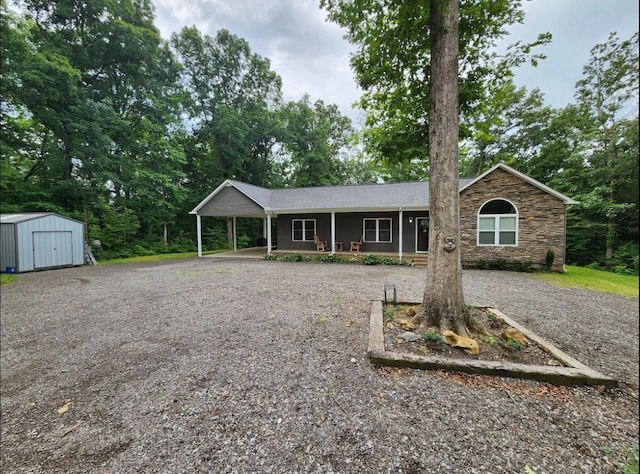 1652 Council Bend Rd, Centerville, TN 37033 - ranch-style home featuring a storage shed, covered porch, driveway, stone siding, and an outbuilding