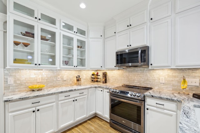 905 W Sagefield Dr, Smyrna, TN 37167 - kitchen featuring appliances with stainless steel finishes, white cabinetry, tasteful backsplash, and light stone countertops