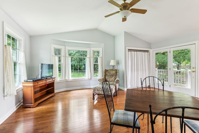 dining space featuring lofted ceiling, wood finished floors, baseboards, and a ceiling fan