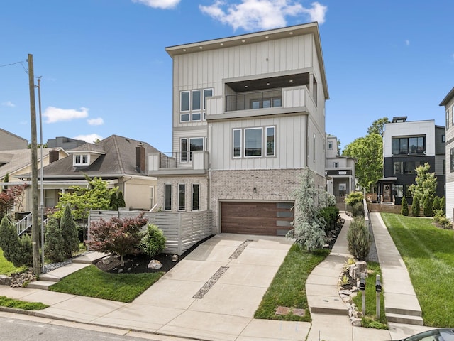 1211A Sigler St, Nashville, TN 37203 - view of front of house with board and batten siding, a balcony, concrete driveway, brick siding, and a garage