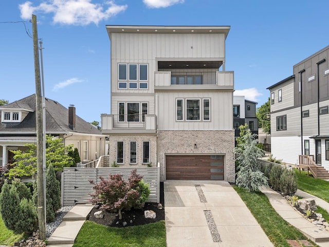 1211A Sigler St, Nashville, TN 37203 - modern home with brick siding, concrete driveway, board and batten siding, fence, and a garage