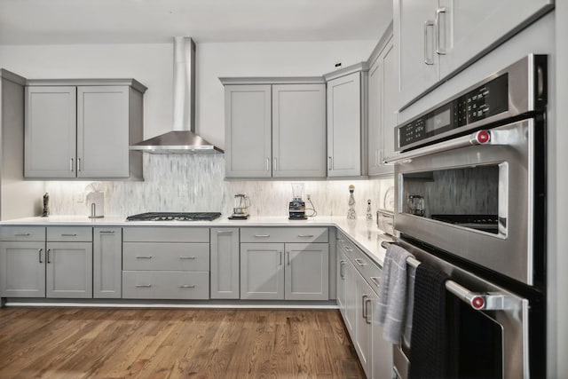 1211A Sigler St, Nashville, TN 37203 - kitchen with gray cabinets, wall chimney range hood, stainless steel appliances, and tasteful backsplash