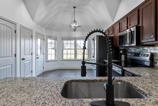 7919 Natahna Ct, Murfreesboro, TN 37127 - kitchen featuring appliances with stainless steel finishes, vaulted ceiling, a chandelier, dark wood finished floors, and light stone counters