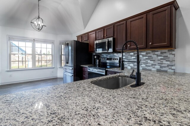 7919 Natahna Ct, Murfreesboro, TN 37127 - kitchen featuring appliances with stainless steel finishes, a chandelier, backsplash, vaulted ceiling, and light stone countertops