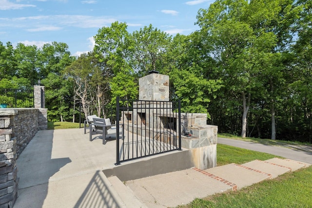 150 Valley Vista Dr, Carthage, TN 37030 - gate featuring an outdoor stone fireplace, view of scattered trees, and a patio area