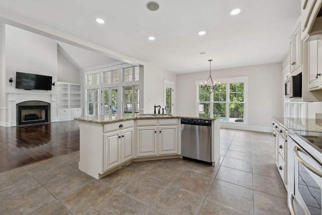 150 Valley Vista Dr, Carthage, TN 37030 - kitchen with stainless steel dishwasher, a sink, a fireplace, light stone counters, and a chandelier