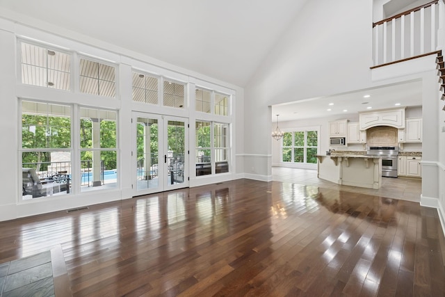 150 Valley Vista Dr, Carthage, TN 37030 - unfurnished living room with high vaulted ceiling, wood finished floors, baseboards, a chandelier, and french doors