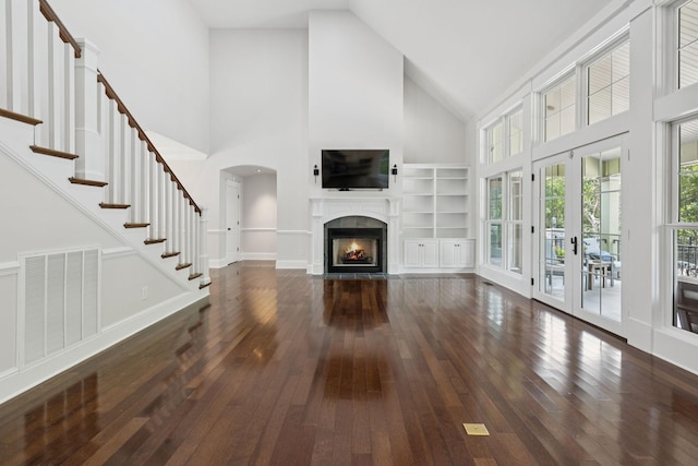 150 Valley Vista Dr, Carthage, TN 37030 - unfurnished living room with high vaulted ceiling, hardwood / wood-style floors, a fireplace with flush hearth, arched walkways, and baseboards