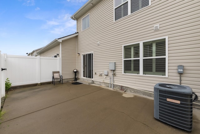 rear view of property featuring central AC, a patio, and fence