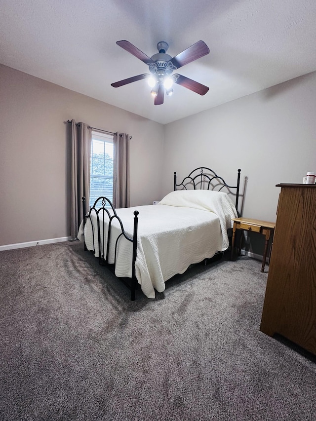 carpeted bedroom with ceiling fan and baseboards
