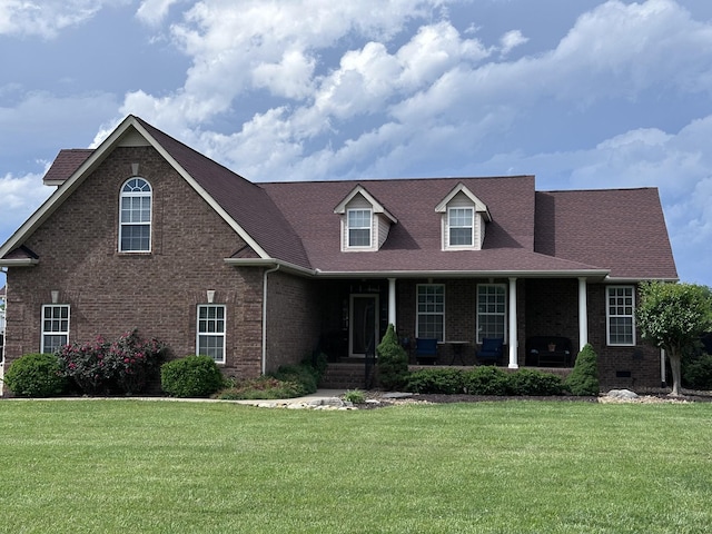 view of front of home featuring brick siding, a front yard, and a porch