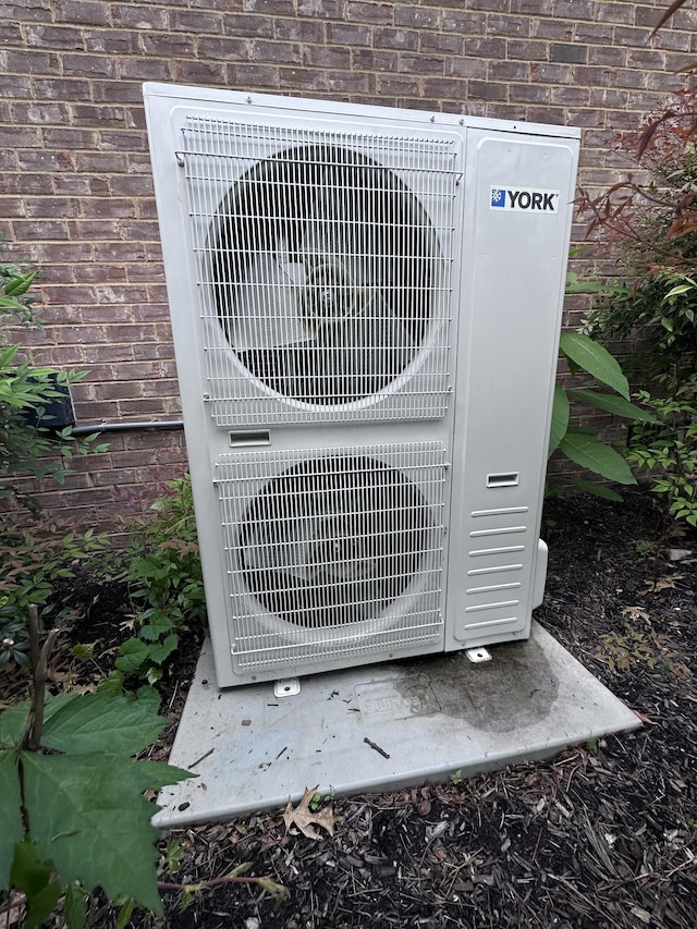 exterior view of brick siding and a cooling unit