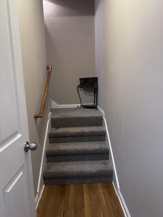 stairs featuring wood finished floors and baseboards