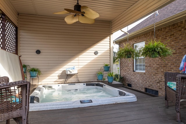 wooden deck with an outdoor hot tub and a ceiling fan
