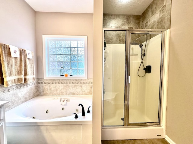 bathroom featuring a shower stall and a tub with jets