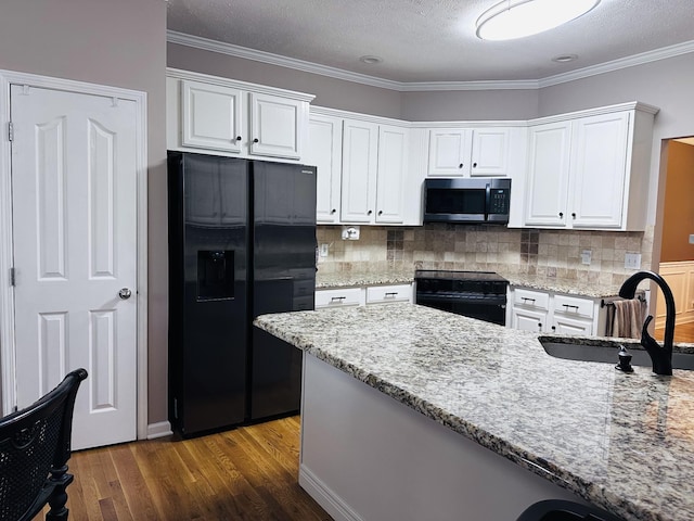 kitchen with black appliances, a sink, white cabinetry, wood finished floors, and crown molding