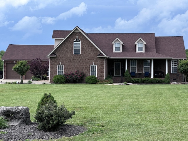 view of front facade with brick siding, covered porch, and a front yard