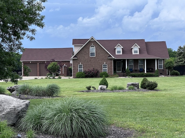 view of front of property with brick siding, a front lawn, covered porch, and a garage