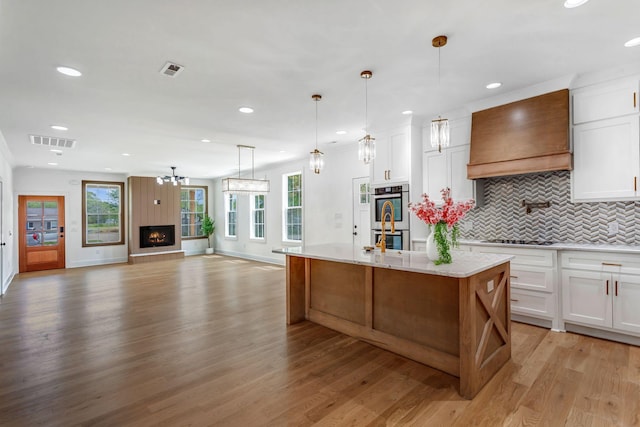 107 Shady St, Summertown, TN 38483 - kitchen with stainless steel double oven, custom range hood, light wood-style flooring, recessed lighting, and decorative backsplash