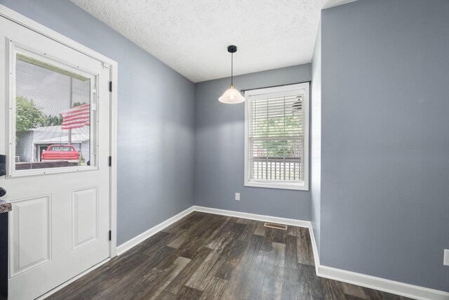 914 Woodland St, Clarksville, TN 37040 - unfurnished dining area featuring baseboards, dark wood-style flooring, and a textured ceiling