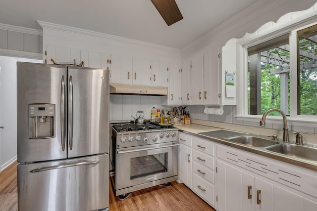 1008 Downey Dr, Nashville, TN 37205 - kitchen with appliances with stainless steel finishes, under cabinet range hood, white cabinets, light wood finished floors, and crown molding
