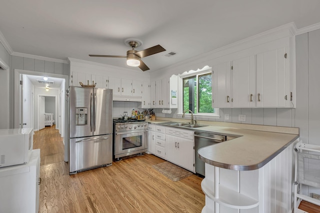 1008 Downey Dr, Nashville, TN 37205 - kitchen featuring appliances with stainless steel finishes, under cabinet range hood, a peninsula, light wood-style flooring, and ornamental molding