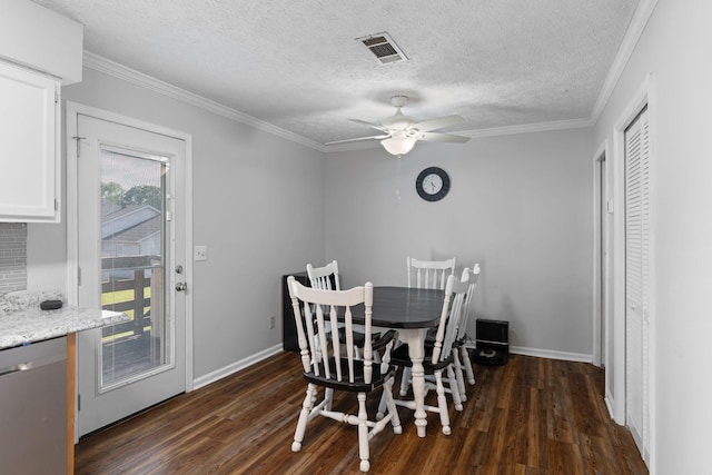 dining room with dark wood-type flooring, ceiling fan, baseboards, crown molding, and a textured ceiling
