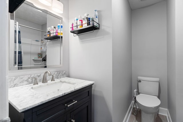 bathroom with baseboards, toilet, vanity, a shower with shower curtain, and wood finished floors